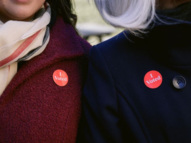 Two people with “I voted” stickers.