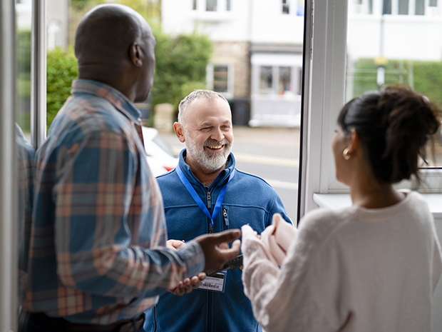 man at door talking to a couple