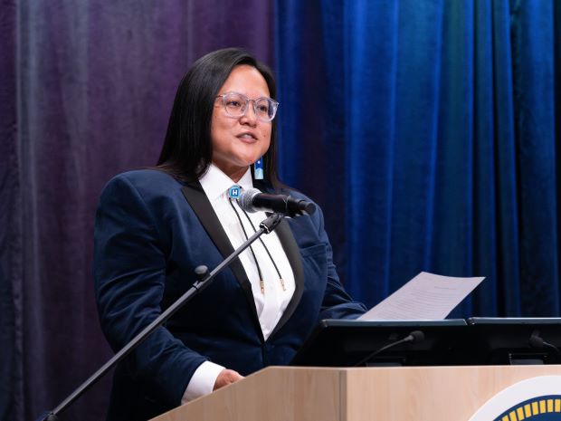Chair Irene Fernando speaking at a podium