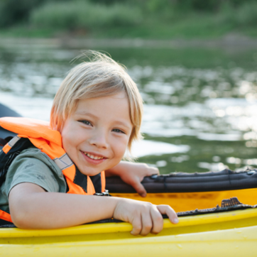 small boy wearing a life jacket in a canoe