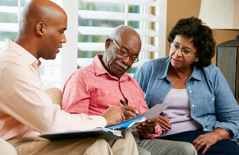 family sitting on couch looking at paperwork