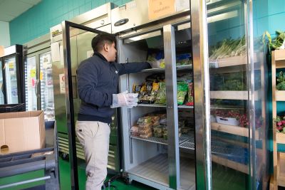 Person stocking a freezer with food at a food rescue organization