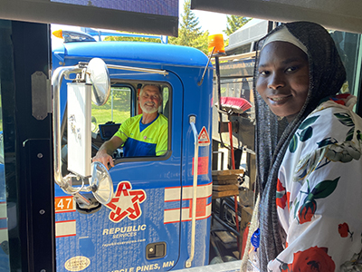 Man in truck with young woman on the side working