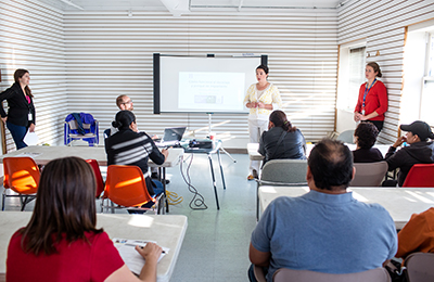 Woman standing at front of room giving a presentation