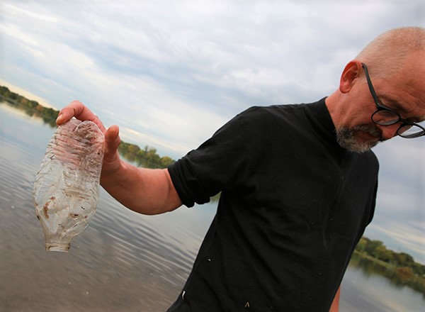 Man holding plastic water bottle litter