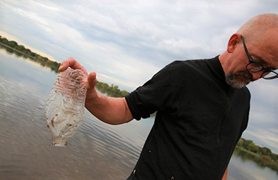 Man holding plastic water bottle litter