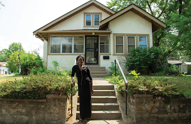 women standing in front of house