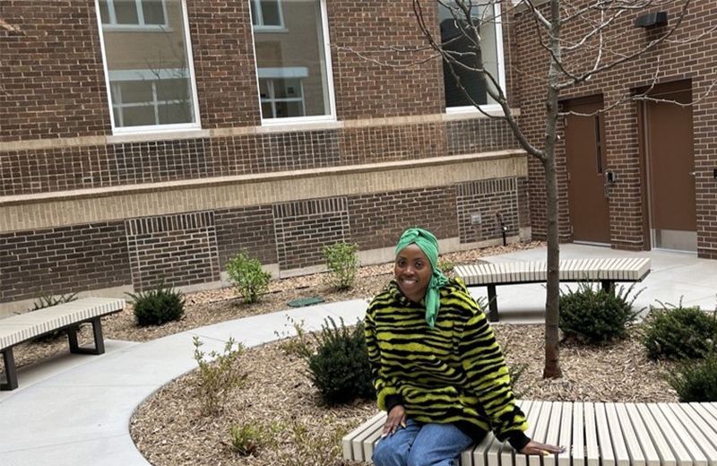 women sitting on a bench outside her apartment