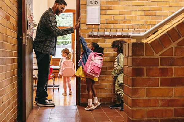 young kids entering classroom and giving the teacher a high five